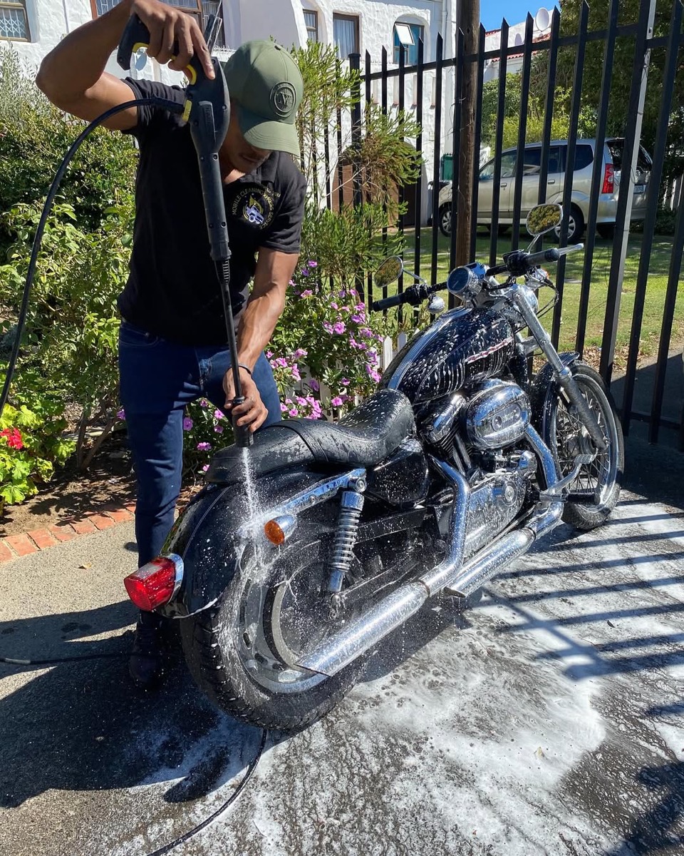 Hydrofit team member pressure washing a Harley-Davidson motorcycle